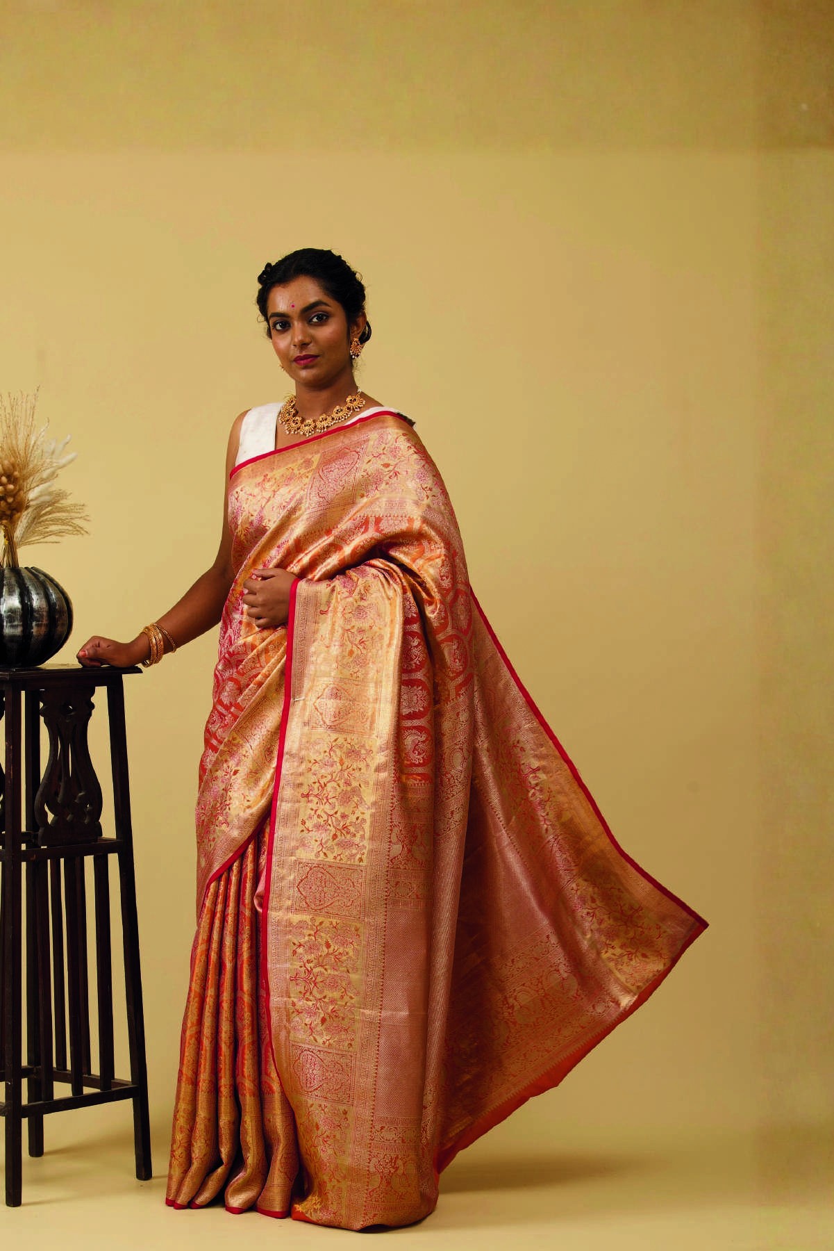 Woman wearing a gold and crimson silk saree