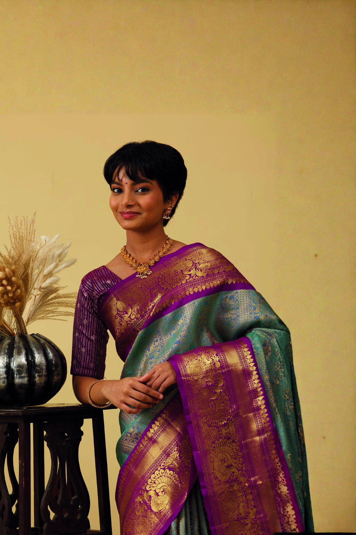 Woman wearing a green and purple Gadwal silk saree